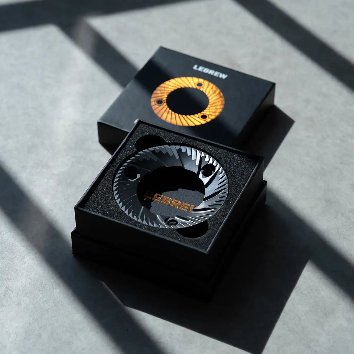 LeBrew Espresso Burr in a black box on a gray surface
